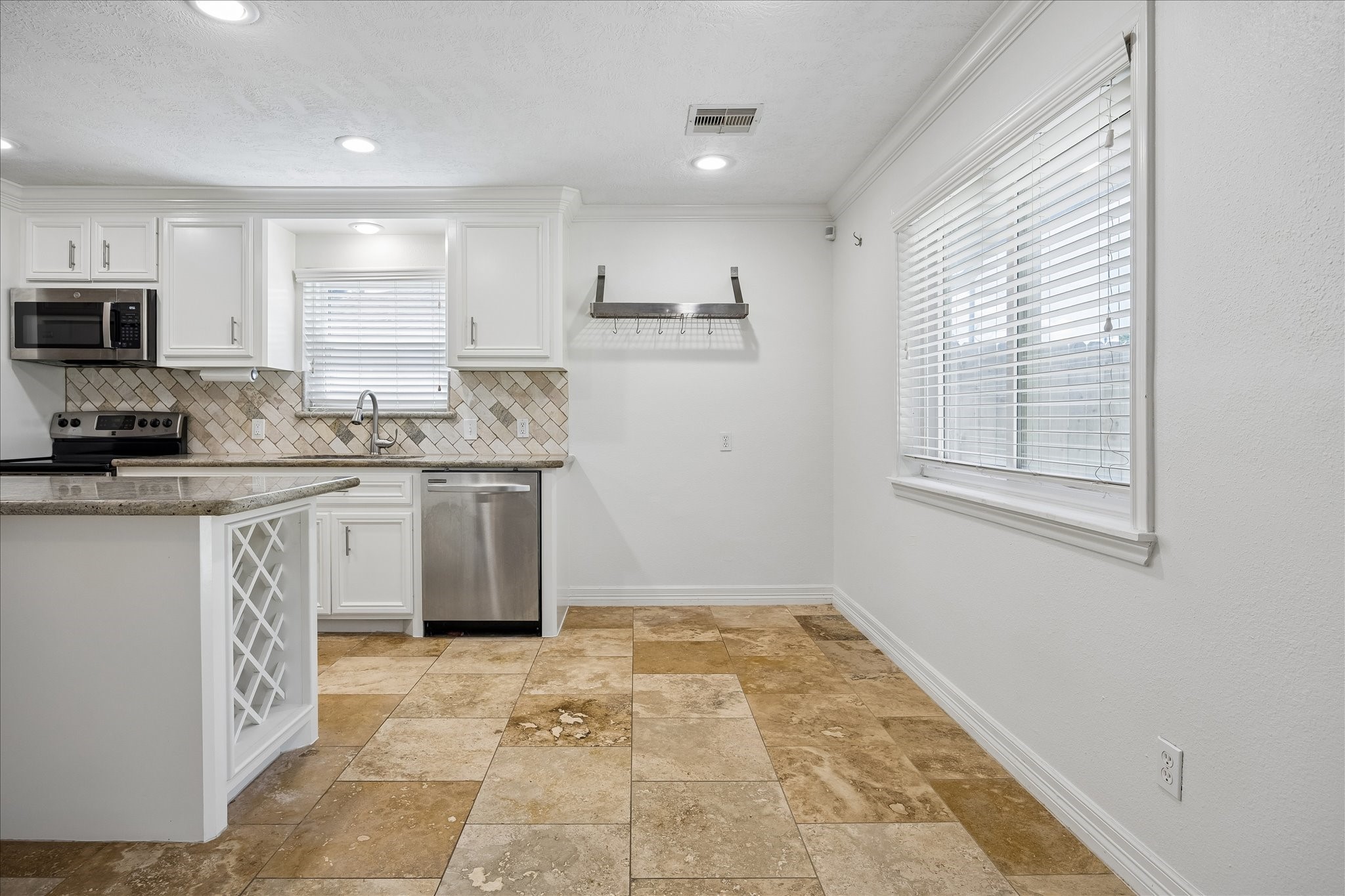 5019 Kinglet Street Houston, TX 77035 - Photo 11 of 24 Breakfast room features travertine flooring & green views of the oversize backyard. Note upgraded windows with two inch blinds throughout.