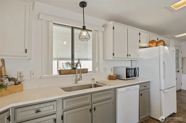 a kitchen with appliances a sink and cabinets