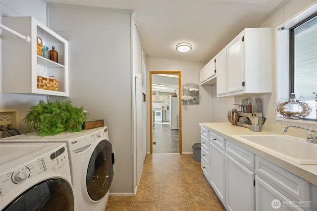 a view of a kitchen with sink washer and dryer