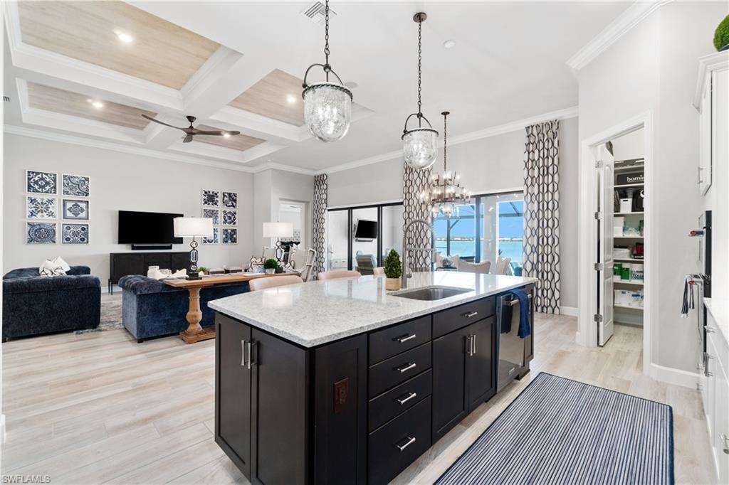 14367 Pine Hollow Drive Estero, FL 33928 - Photo 13 of 50 a large kitchen with kitchen island a sink and a stove top oven