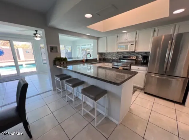 a kitchen with stainless steel appliances granite countertop a stove a sink a microwave and a refrigerator