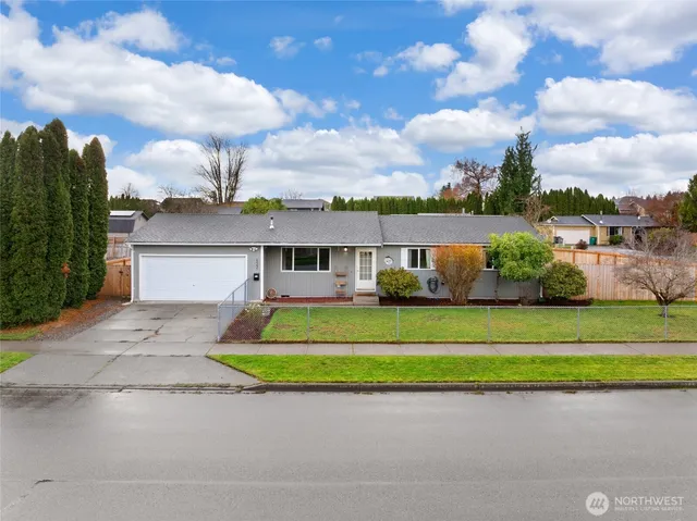 a front view of a house with a garden and a car parked