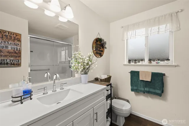 a bathroom with a sink a toilet and mirror