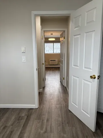 a view of a hallway view with wooden floor and closet