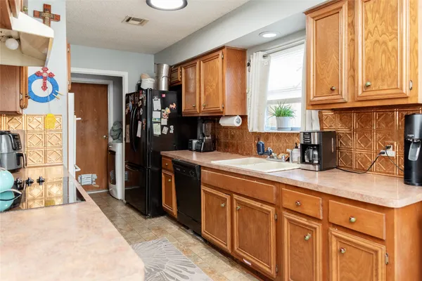 a kitchen with stainless steel appliances granite countertop a sink a stove and a refrigerator
