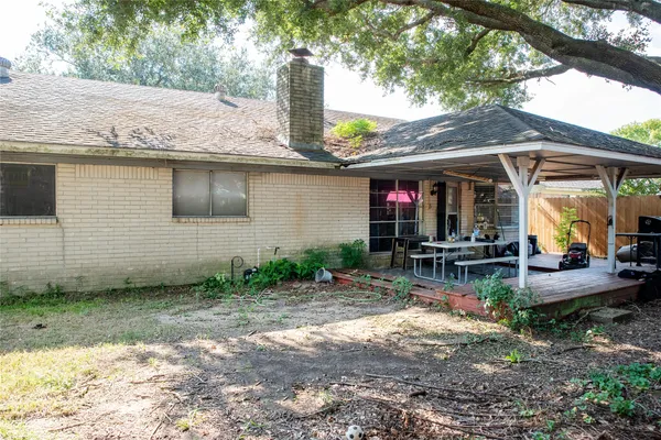 a view of a patio with table and chairs under an umbrella