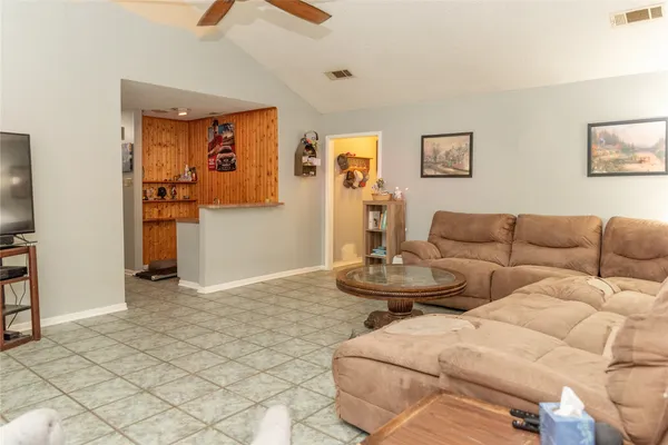 a living room with couches and a dining table with wooden floor