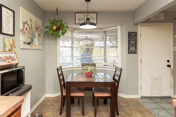 a dining room with furniture potted plants and wooden floor