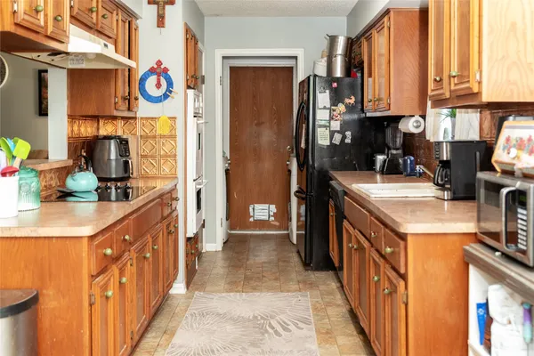 a kitchen with stainless steel appliances granite countertop a sink and a refrigerator