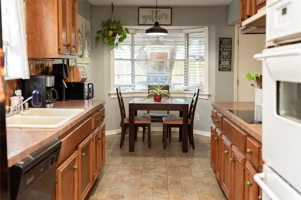a dining hall with stainless steel appliances a sink stove and table chair