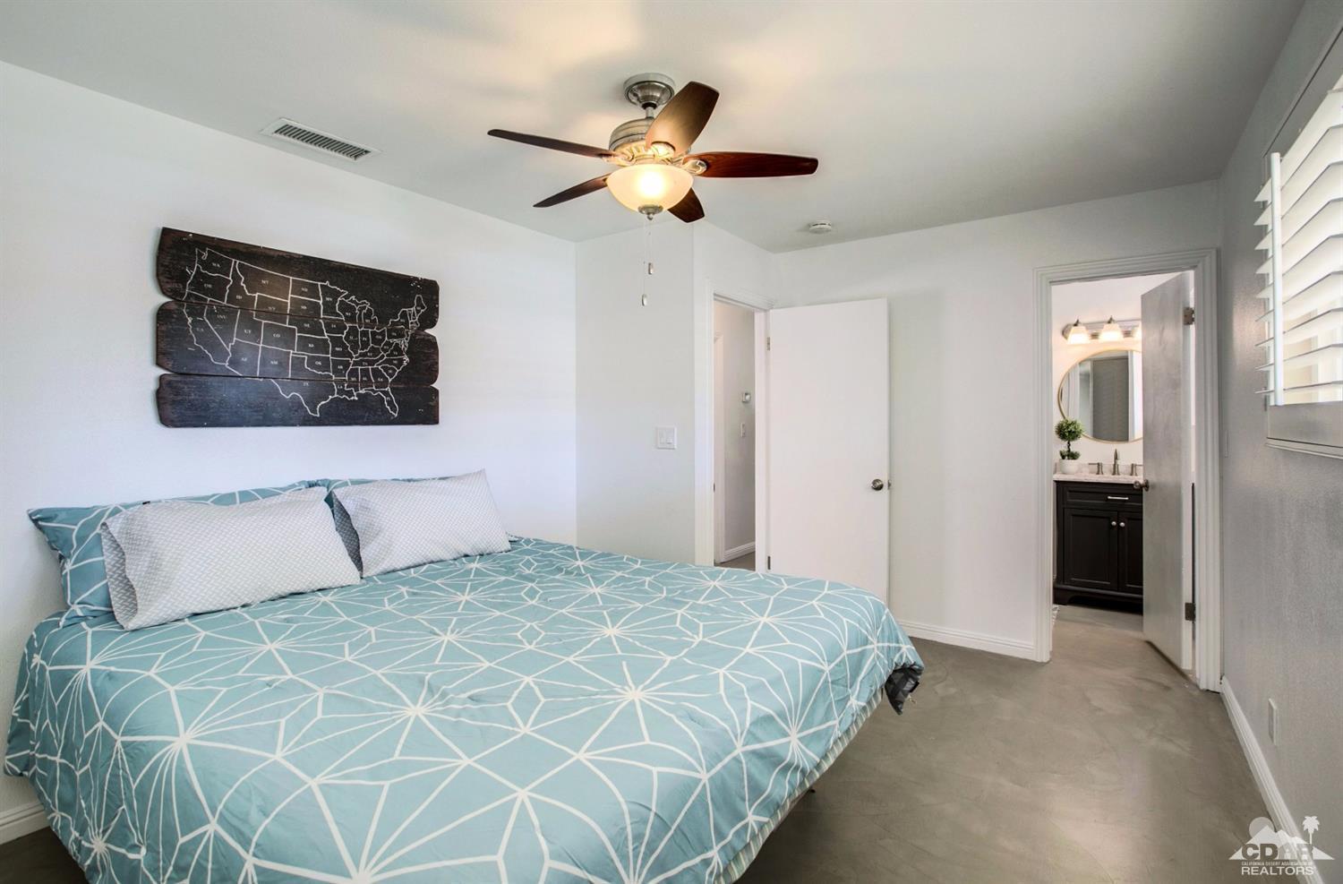 70070 Chappel Road Rancho Mirage, CA 92270 - Photo 16 of 32 a bedroom with a large bed and a chandelier