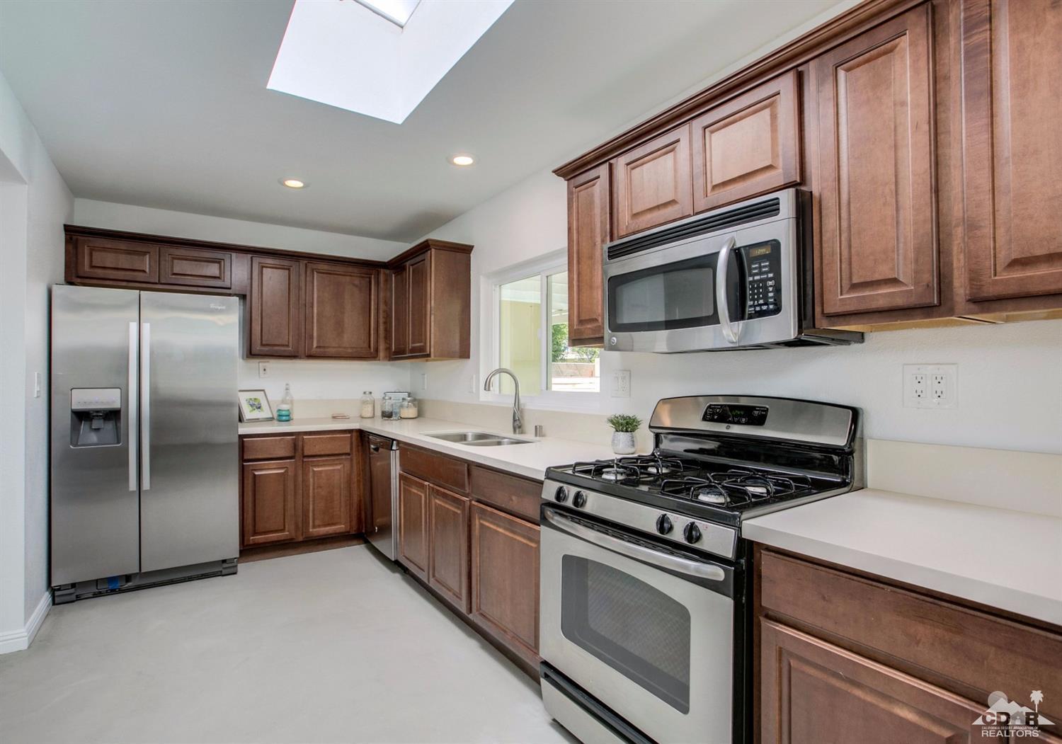 70070 Chappel Road Rancho Mirage, CA 92270 - Photo 9 of 32 a kitchen with stainless steel appliances granite countertop a stove microwave sink and refrigerator