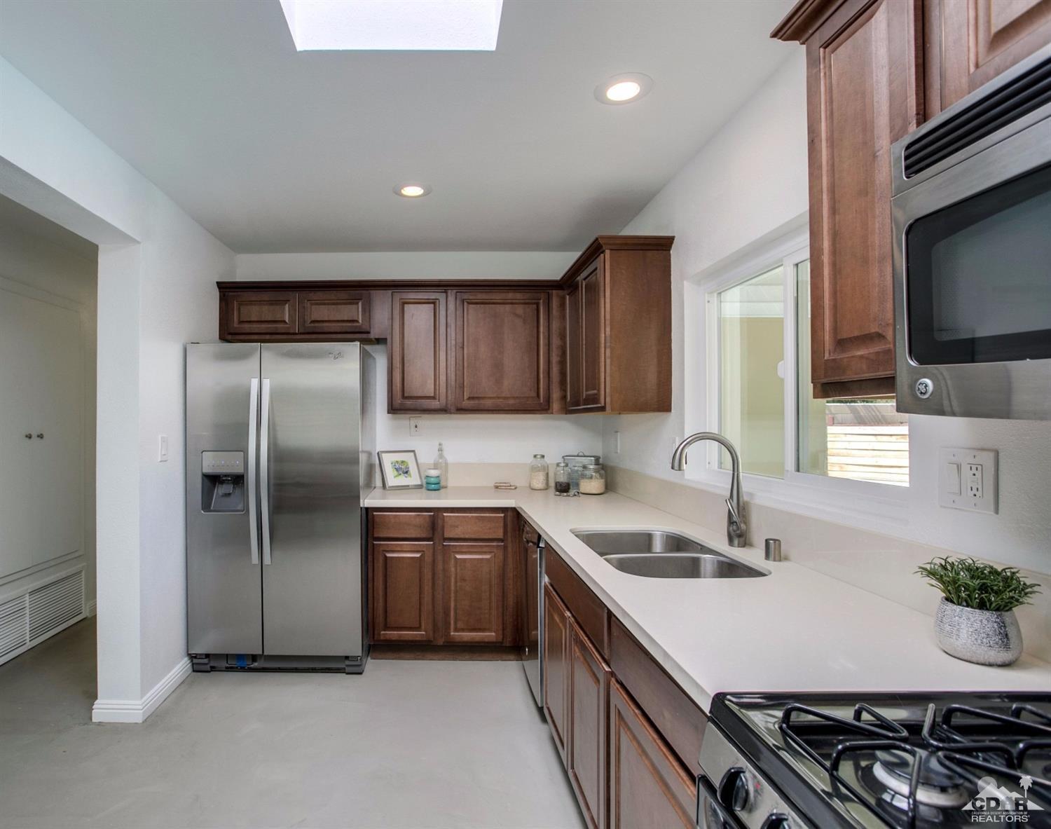 70070 Chappel Road Rancho Mirage, CA 92270 - Photo 10 of 32 a kitchen with stainless steel appliances granite countertop a sink stove and refrigerator