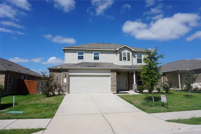 a front view of a house with a garden and yard