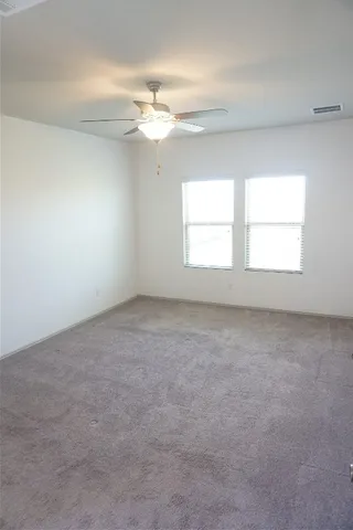 an empty room with a window and a ceiling fan