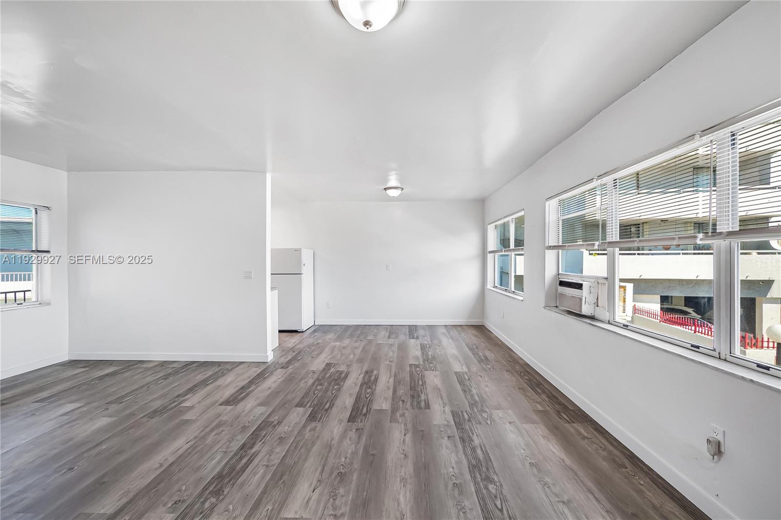 7271 Gary Avenue, Unit 6 Miami Beach, FL 33141 - Photo 12 of 23 an empty room with wooden floor and windows