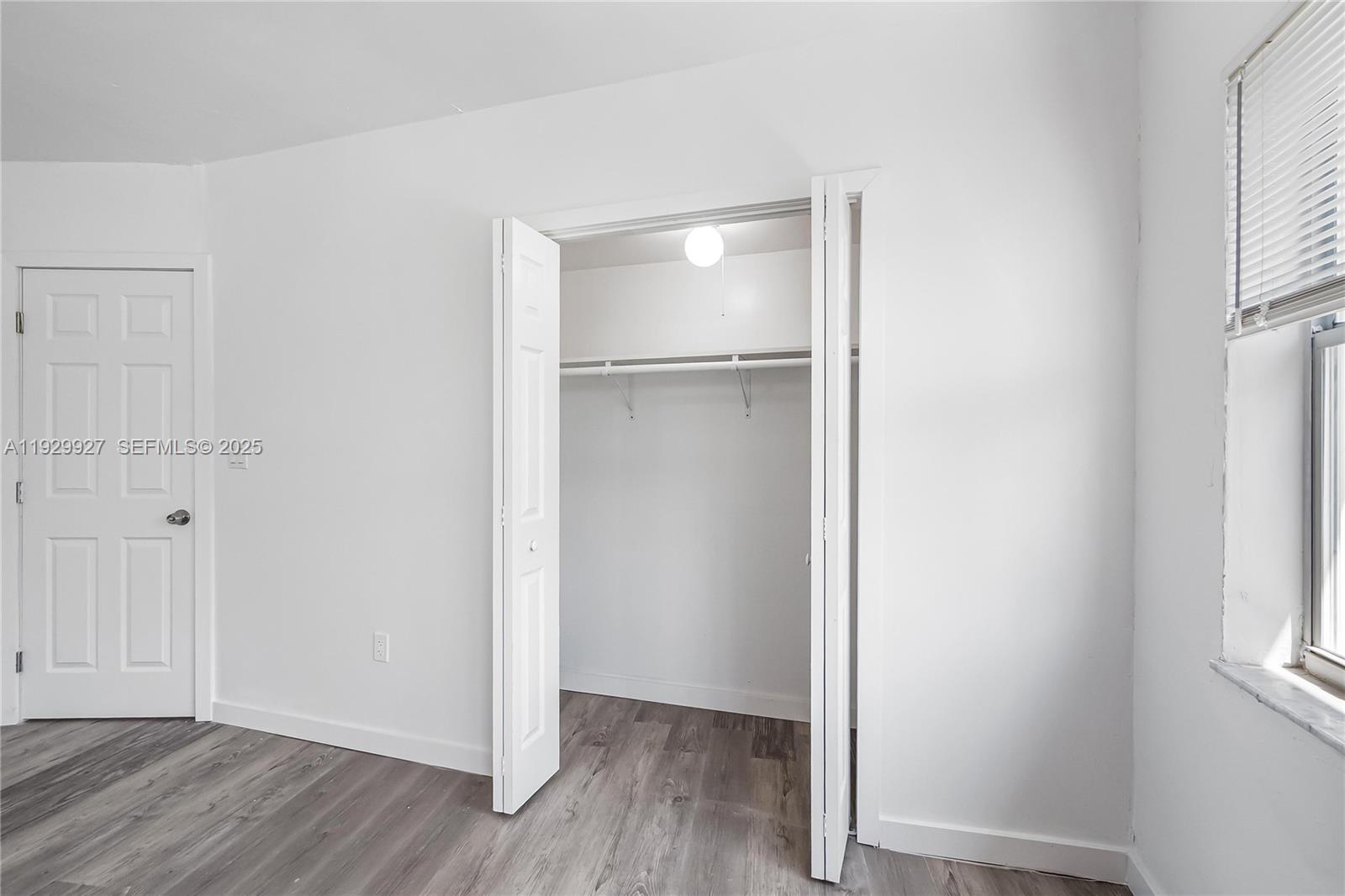 7271 Gary Avenue, Unit 6 Miami Beach, FL 33141 - Photo 17 of 23 a view of an empty room with wooden floor and a window