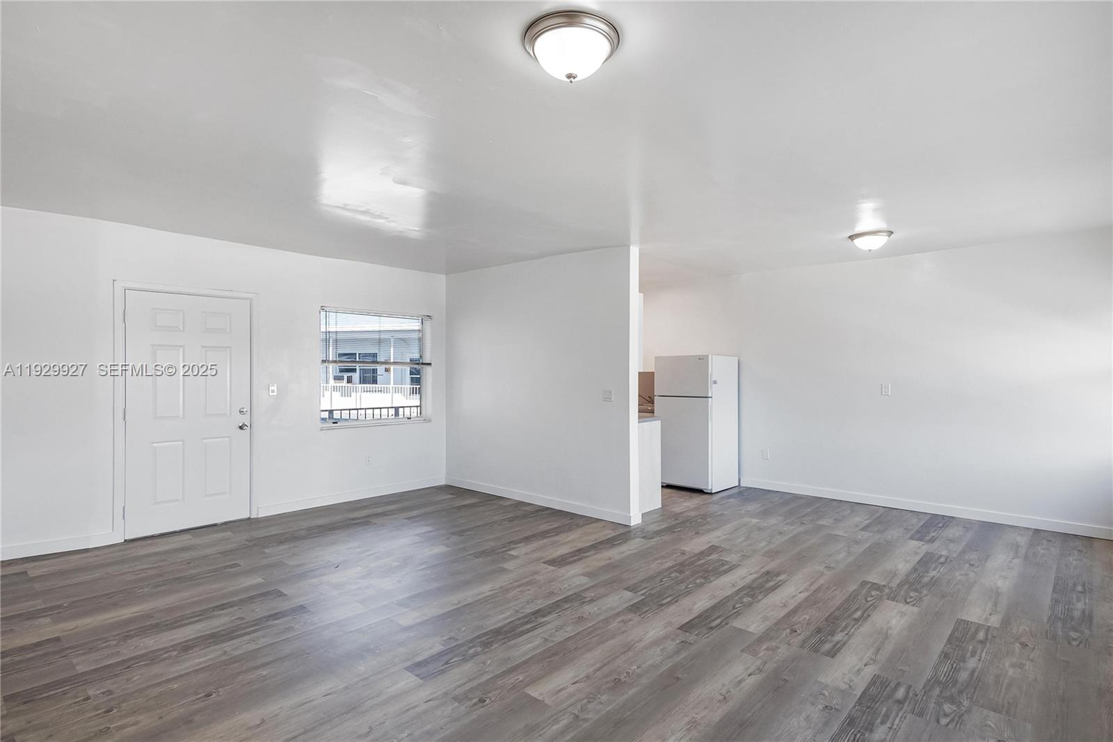 7271 Gary Avenue, Unit 6 Miami Beach, FL 33141 - Photo 4 of 23 an empty room with wooden floor and windows