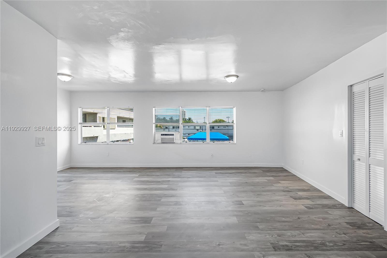 7271 Gary Avenue, Unit 6 Miami Beach, FL 33141 - Photo 10 of 23 an empty room with wooden floor and windows