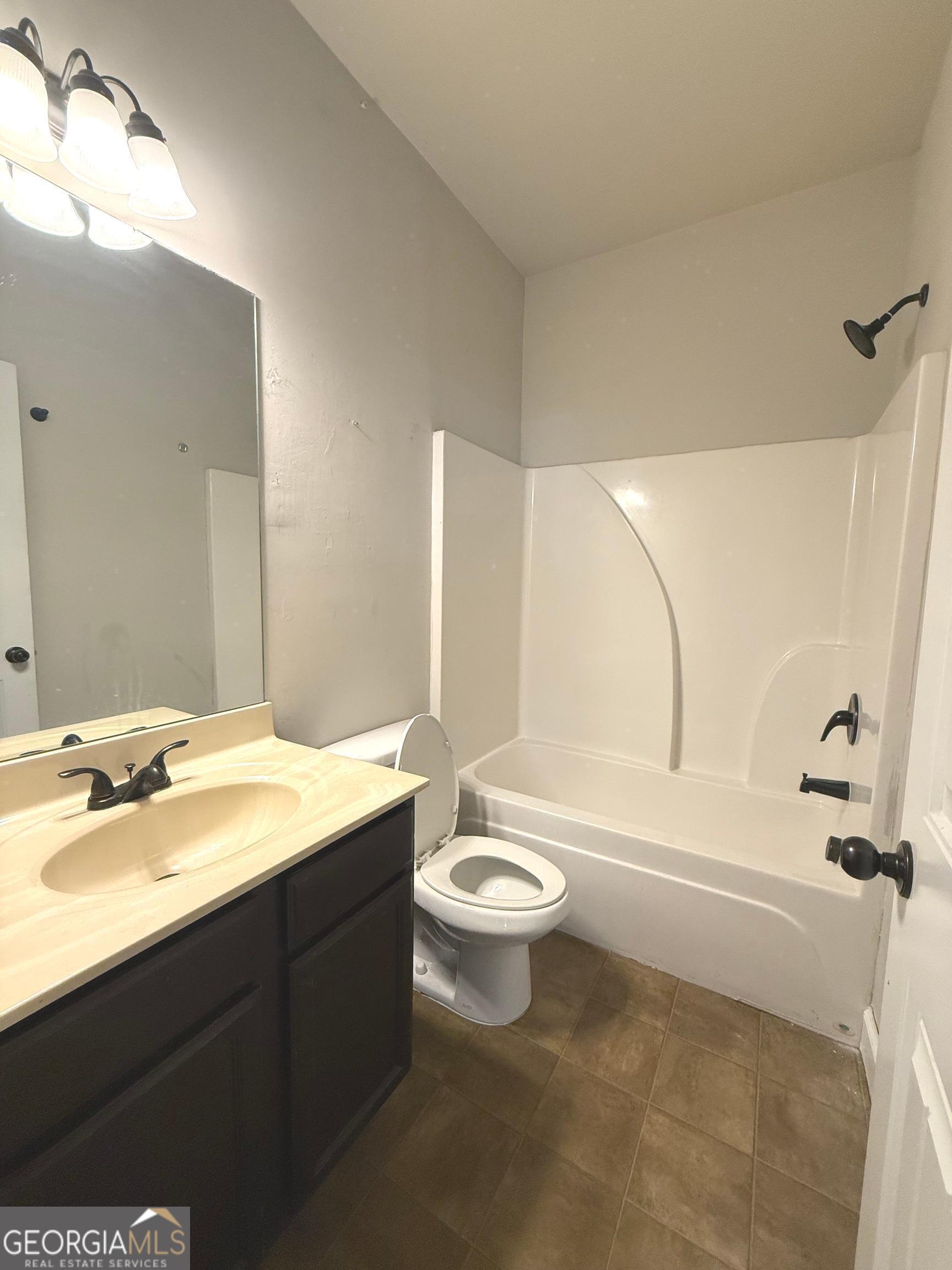 9159 Dover Street Lithia Springs, GA 30122 - Photo 11 of 23 a bathroom with a double vanity sink toilet mirror and bathtub