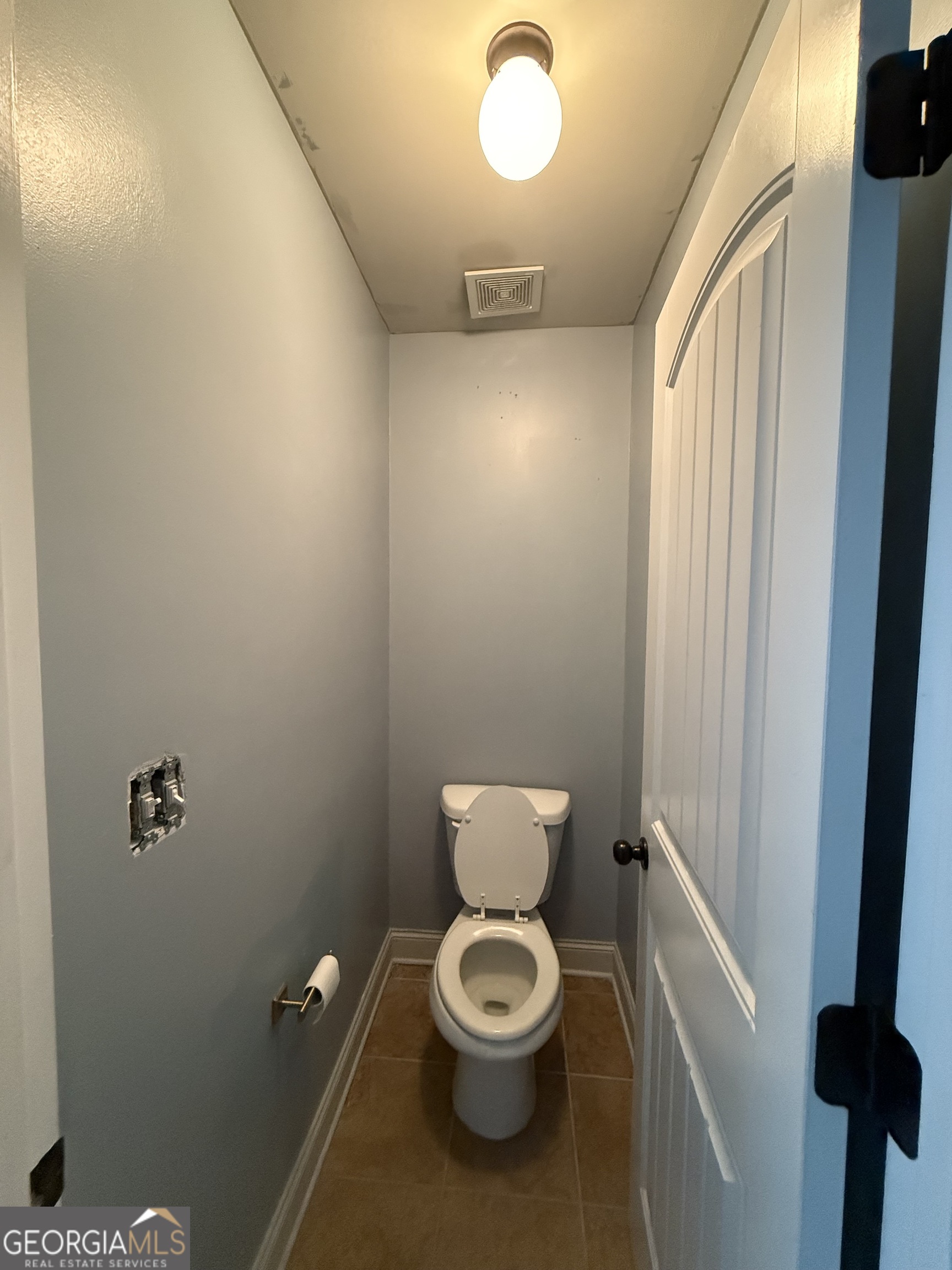 9159 Dover Street Lithia Springs, GA 30122 - Photo 20 of 23 a white toilet sitting next to a bathroom sink and vanity