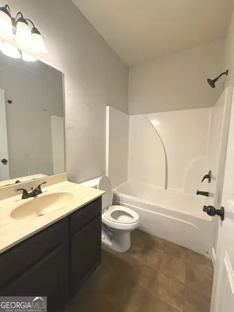 a bathroom with a double vanity sink toilet mirror and bathtub