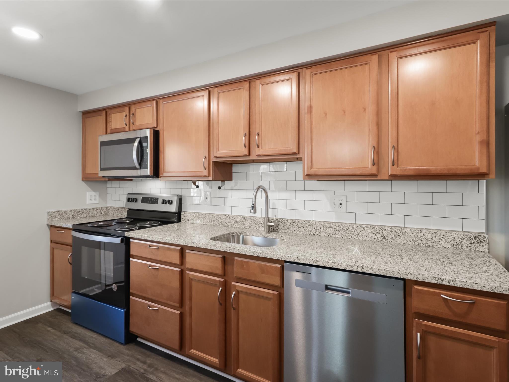 1026 Circle Drive Halethorpe, MD 21227 - Photo 16 of 37 a kitchen with stainless steel appliances granite countertop a sink stove and microwave