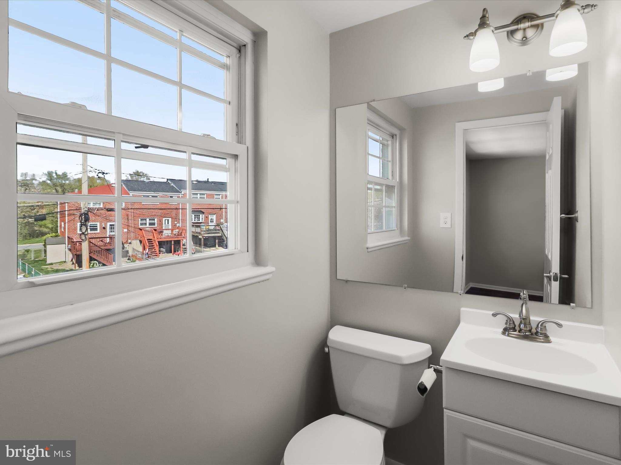 1026 Circle Drive Halethorpe, MD 21227 - Photo 22 of 37 a bathroom with a toilet a sink and a large mirror