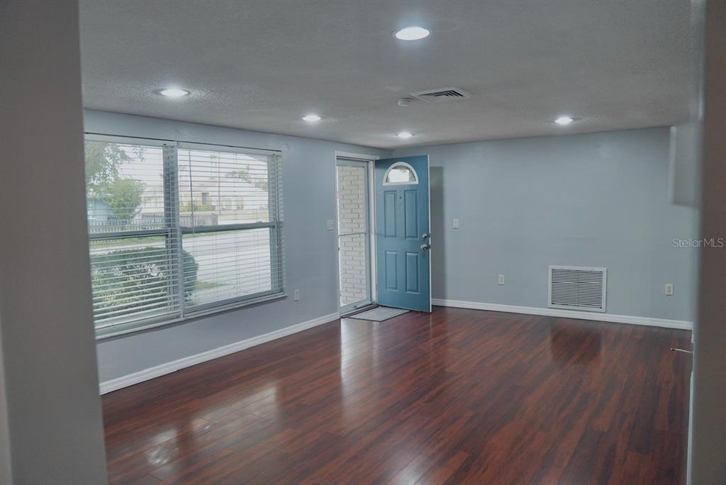 7944 Yucca Drive New Port Richey, FL 34653 - Photo 11 of 26 an empty room with wooden floor and windows