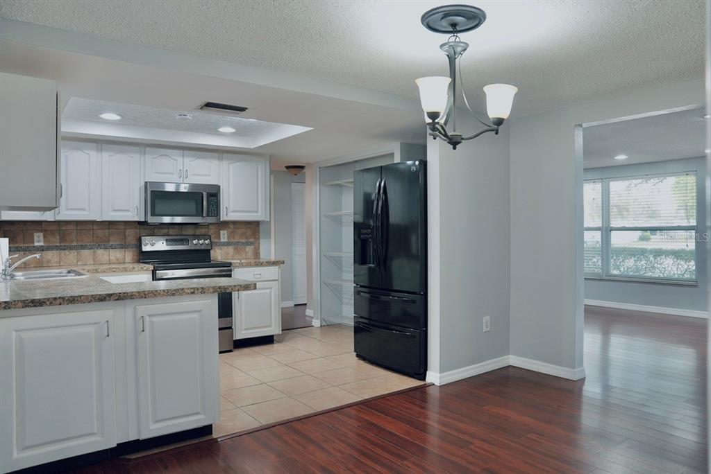 7944 Yucca Drive New Port Richey, FL 34653 - Photo 4 of 26 a kitchen with stainless steel appliances granite countertop a stove a sink and a refrigerator