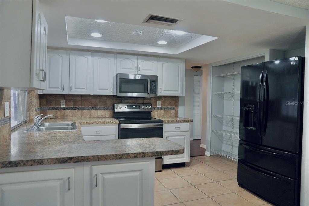 7944 Yucca Drive New Port Richey, FL 34653 - Photo 6 of 26 a kitchen with stainless steel appliances granite countertop a refrigerator and a sink