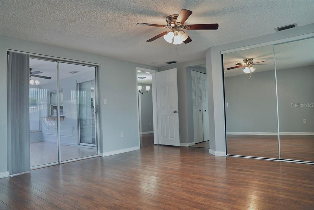 7944 Yucca Drive New Port Richey, FL 34653 - Photo 7 of 26 a view of empty room with wooden floor and fan