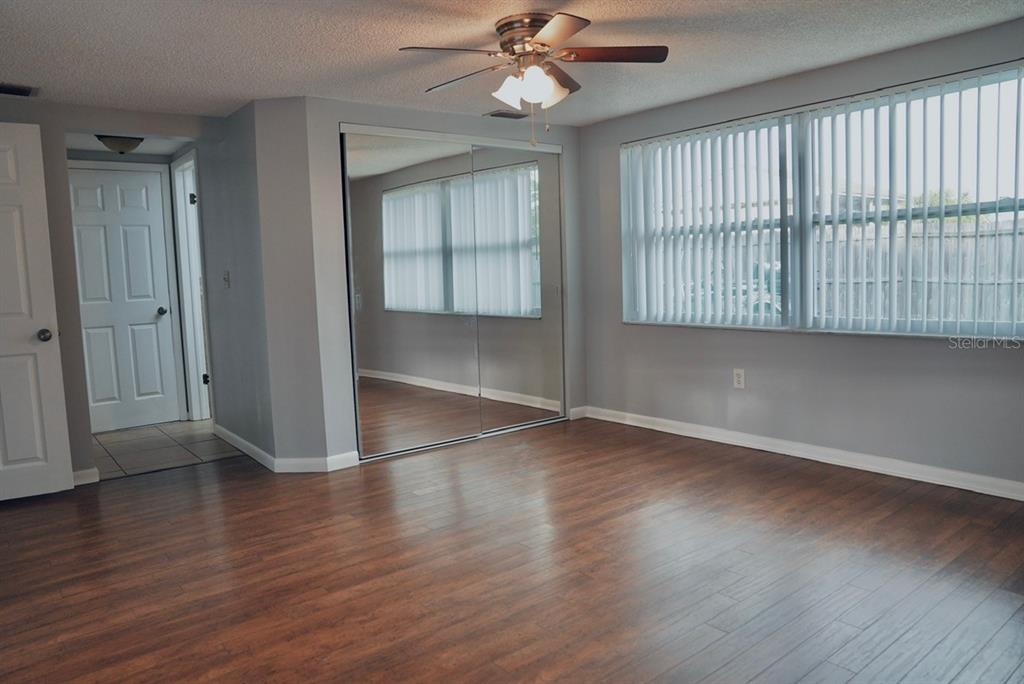7944 Yucca Drive New Port Richey, FL 34653 - Photo 8 of 26 an empty room with wooden floor fan and windows