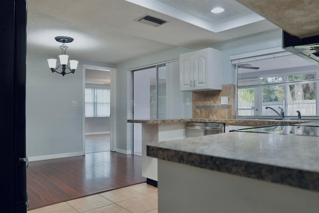 7944 Yucca Drive New Port Richey, FL 34653 - Photo 10 of 26 a kitchen with kitchen island granite countertop a sink cabinets and stainless steel appliances