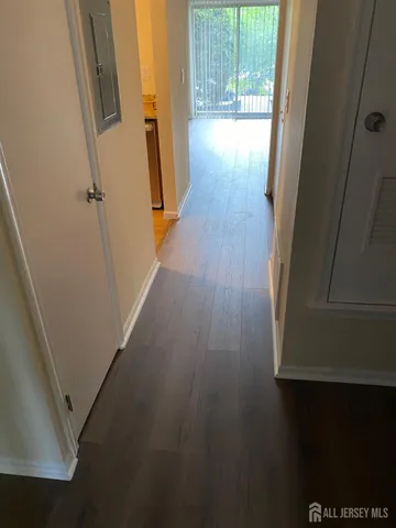 a view of a hallway with wooden floor and stairs