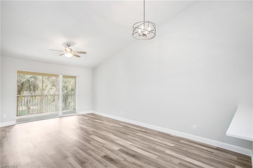 209 Robin Hood Circle, Unit 5201 Naples, FL 34104 - Photo 11 of 30 wooden floor in an empty room with a window