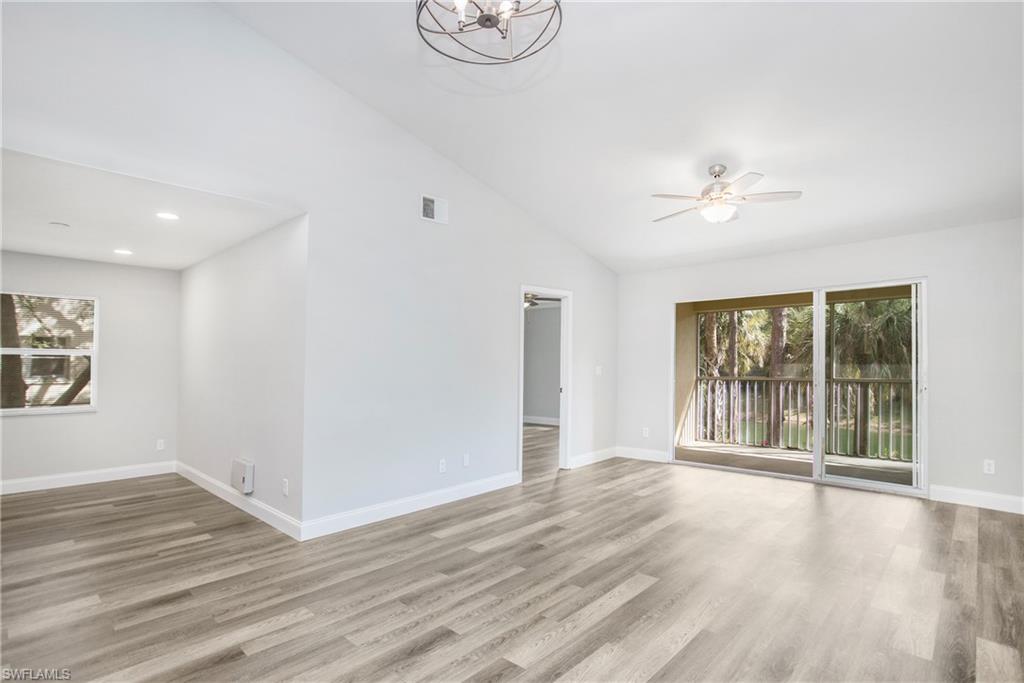 209 Robin Hood Circle, Unit 5201 Naples, FL 34104 - Photo 12 of 30 wooden floor in an empty room with a window