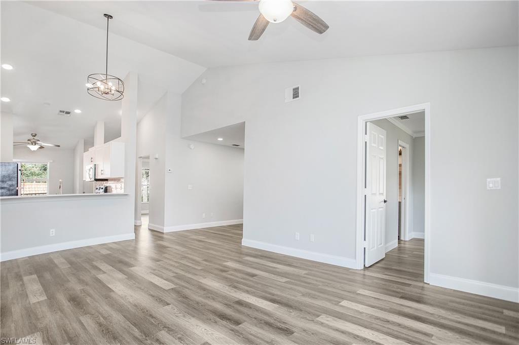 209 Robin Hood Circle, Unit 5201 Naples, FL 34104 - Photo 13 of 30 an empty room with wooden floor and windows