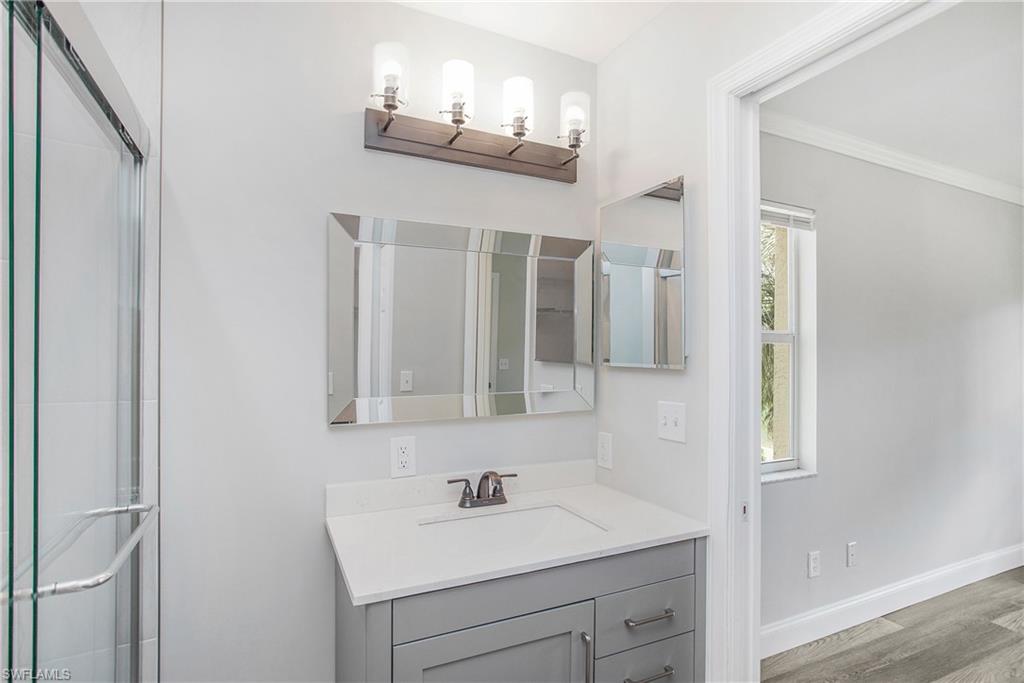 209 Robin Hood Circle, Unit 5201 Naples, FL 34104 - Photo 16 of 30 a bathroom with a sink and a mirror