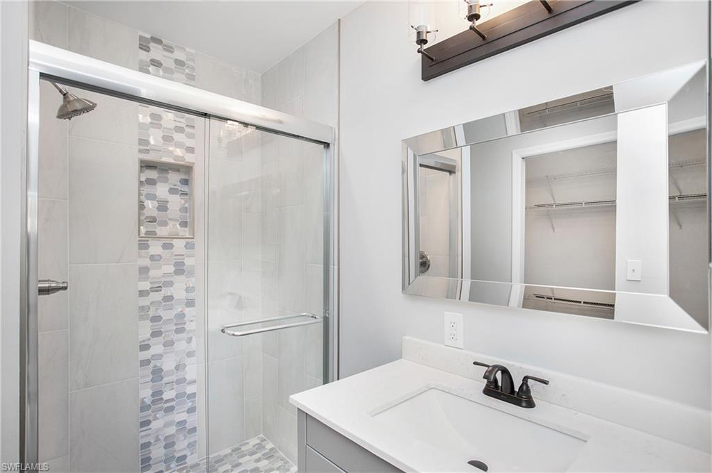 209 Robin Hood Circle, Unit 5201 Naples, FL 34104 - Photo 17 of 30 a bathroom with a sink and a mirror