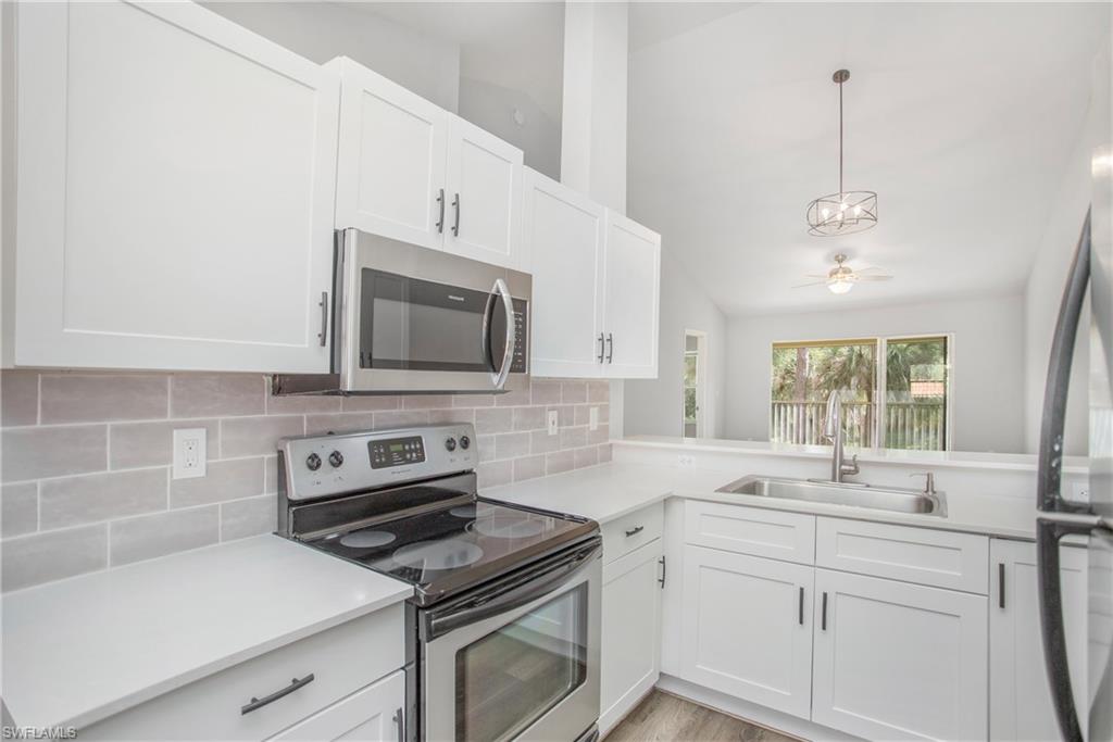 209 Robin Hood Circle, Unit 5201 Naples, FL 34104 - Photo 4 of 30 a kitchen with a sink stove and microwave