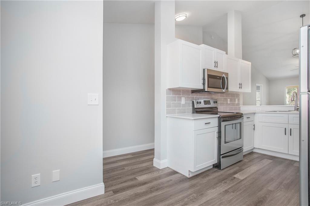 209 Robin Hood Circle, Unit 5201 Naples, FL 34104 - Photo 5 of 30 a kitchen with a microwave stove top oven and sink