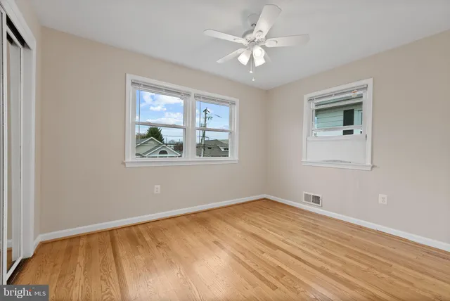a view of empty room with wooden floor