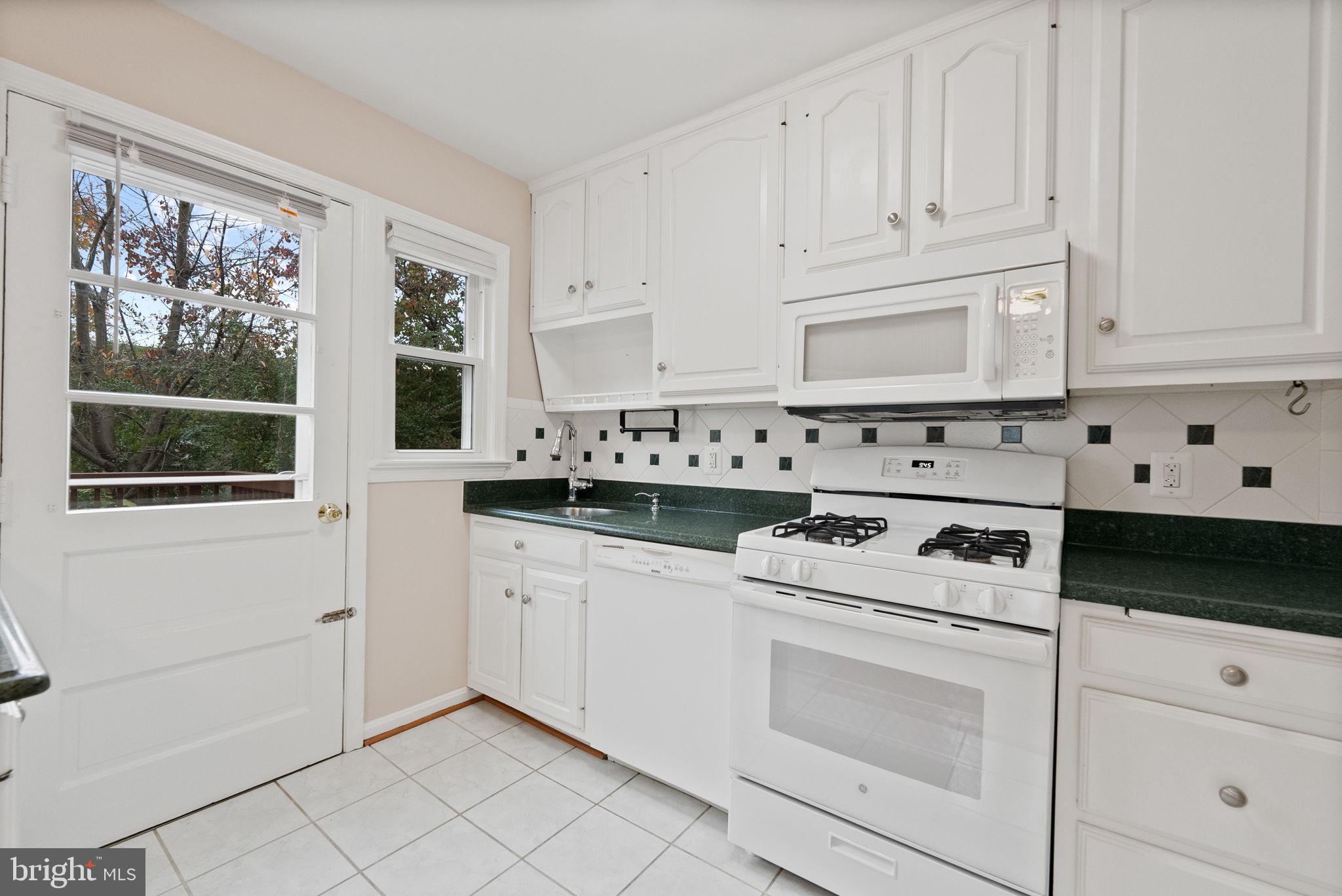 107 East Del Ray Avenue Alexandria, VA 22301 - Photo 19 of 30 a kitchen with white cabinets and white appliances