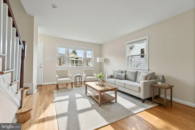 a living room with furniture a rug a lamp and a window
