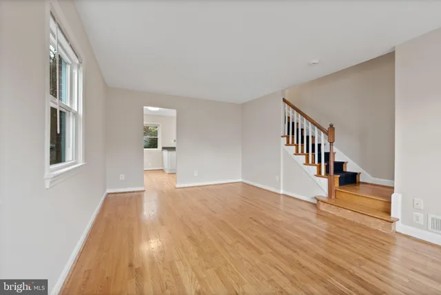 a view of empty room with wooden floor and stairs