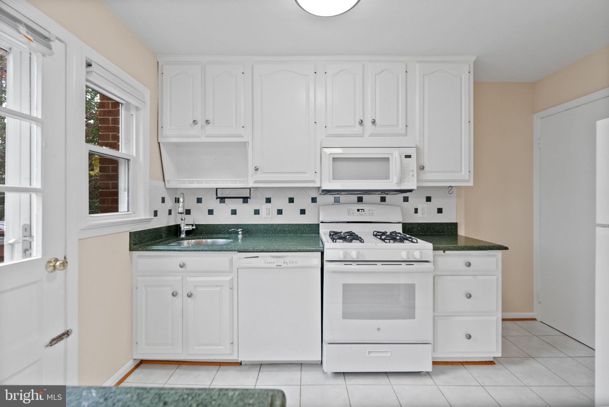 107 East Del Ray Avenue Alexandria, VA 22301 - Photo 10 of 30 a kitchen with white cabinets and white appliances