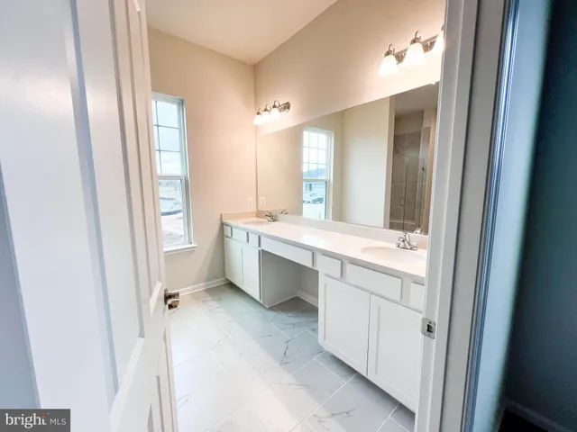 a bathroom with a double vanity sink a mirror and a bathtub
