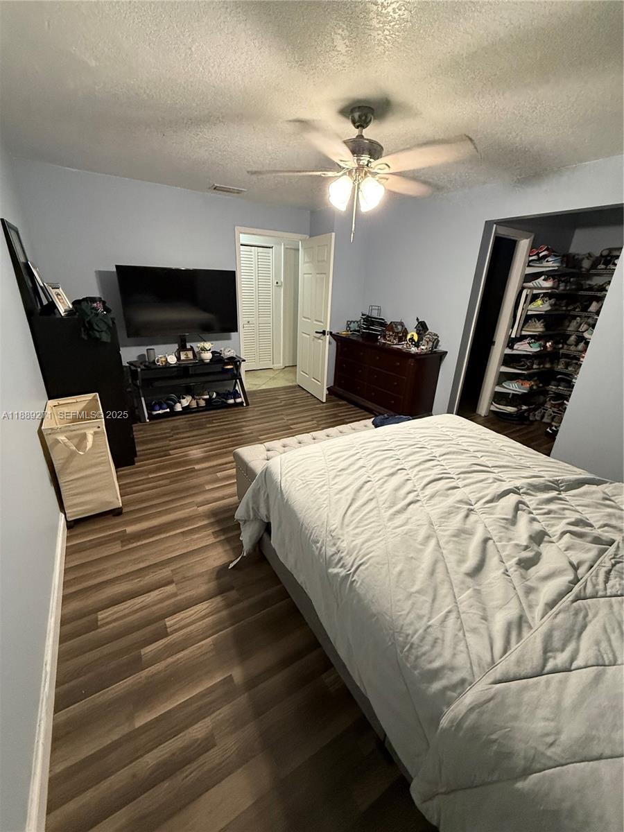 13060 Southwest 263rd Terrace Homestead, FL 33032 - Photo 18 of 30 a spacious bedroom with a bed and a chandelier