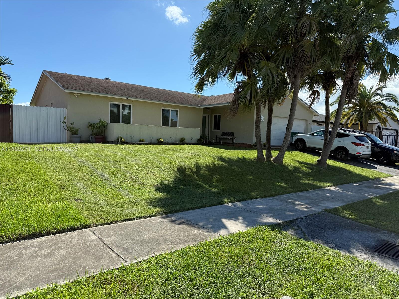 13060 Southwest 263rd Terrace Homestead, FL 33032 - Photo 2 of 30 a front view of a house with a garden and tree